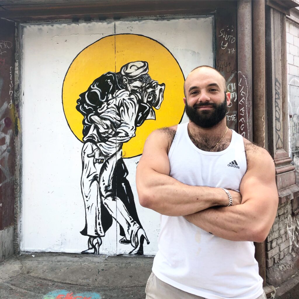 Justin T. Russo standing in front of his illustration "Kissing it All Goodbye" inspired by the famous 1945 Eisdenstadt photo.