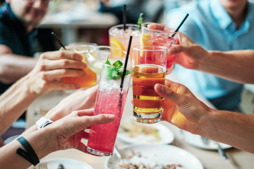 Close shot of friends or family holding their drinks up to cheers