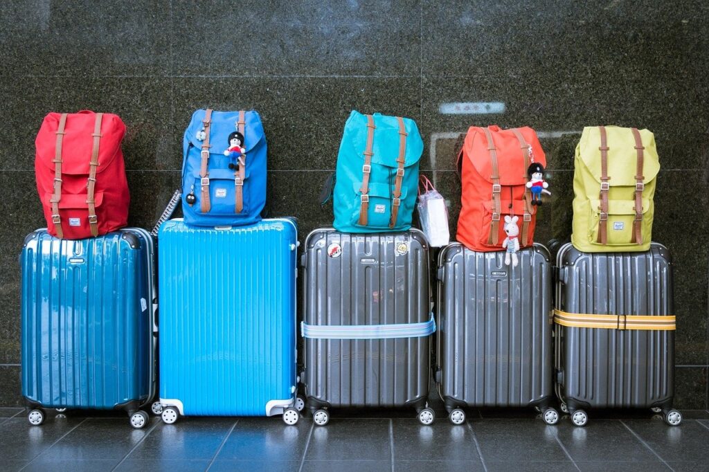 five suitcases with five backpacks on top of each