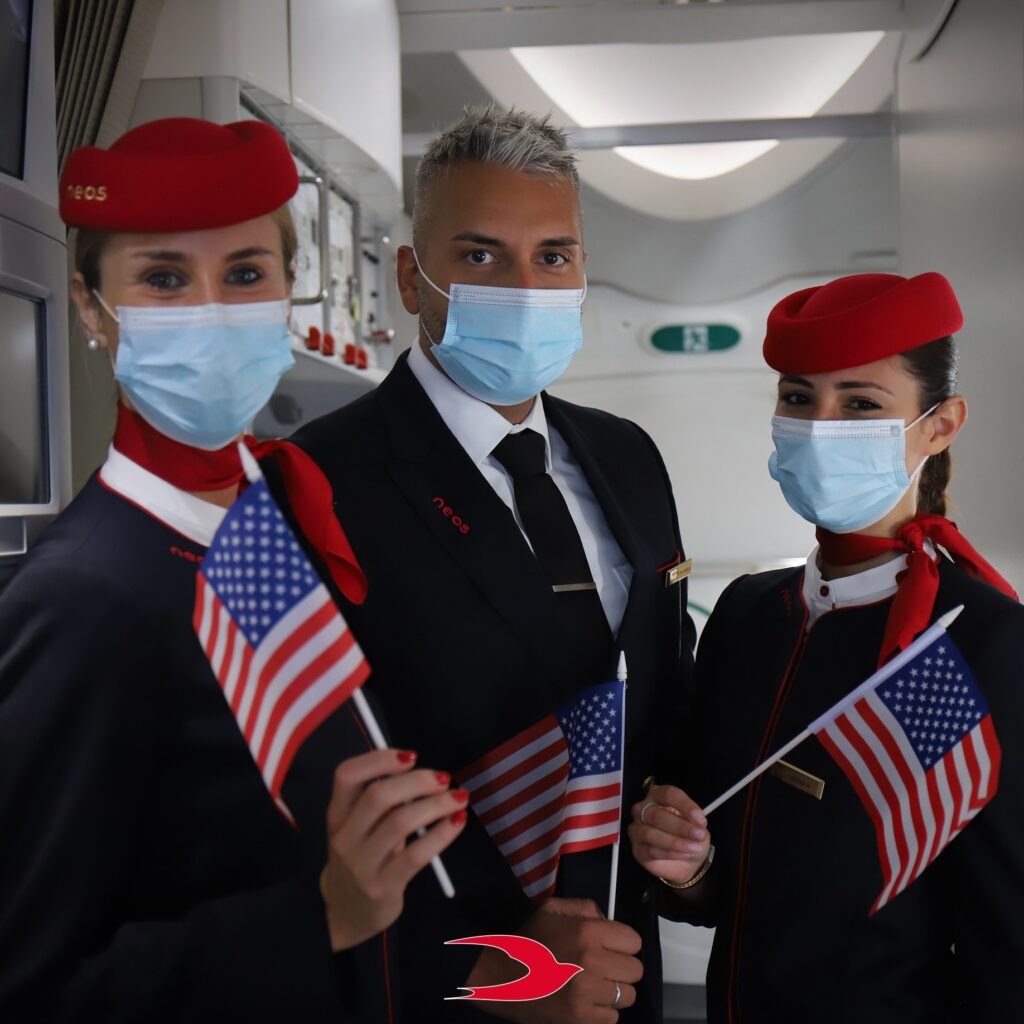 Flight attendants holding American flag (Photo Credit: Neos Air)