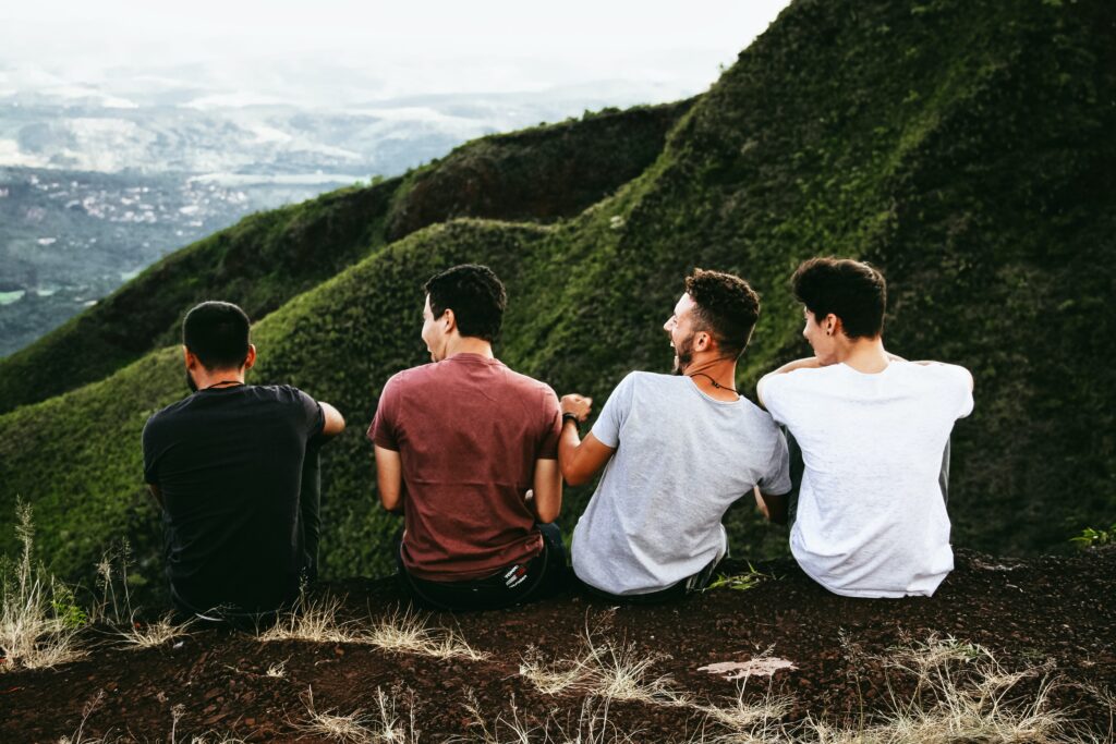 Group of friends sitting on a mountain with a great panoramic view.