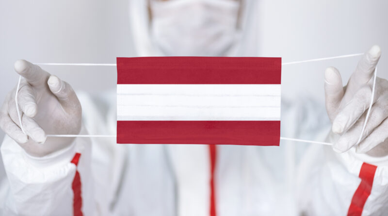 Healthcare personnel is holding Austrian Flag shaped surgical mask.