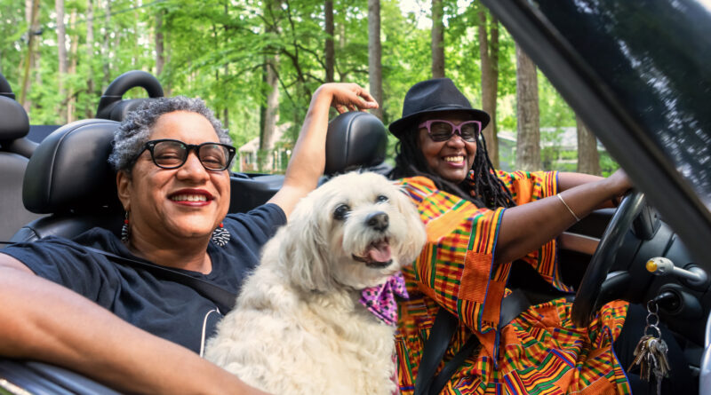 LGBT family driving in their convertible (Photo Credit: iStock)