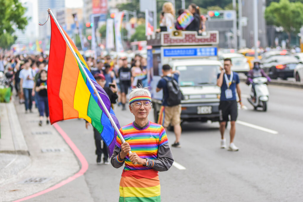 Chi Chia Wei, the first Taiwanese gay civil rights activist, with his rainbow flag in the front of a parade for LGBTQ+ Pride in Kaohsiung. (Photo Credit: shutterstock)