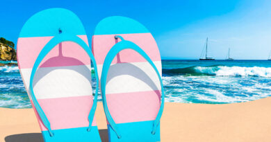 Transgender flag flip flops on a beach (Photo Credit: Shutterstock)