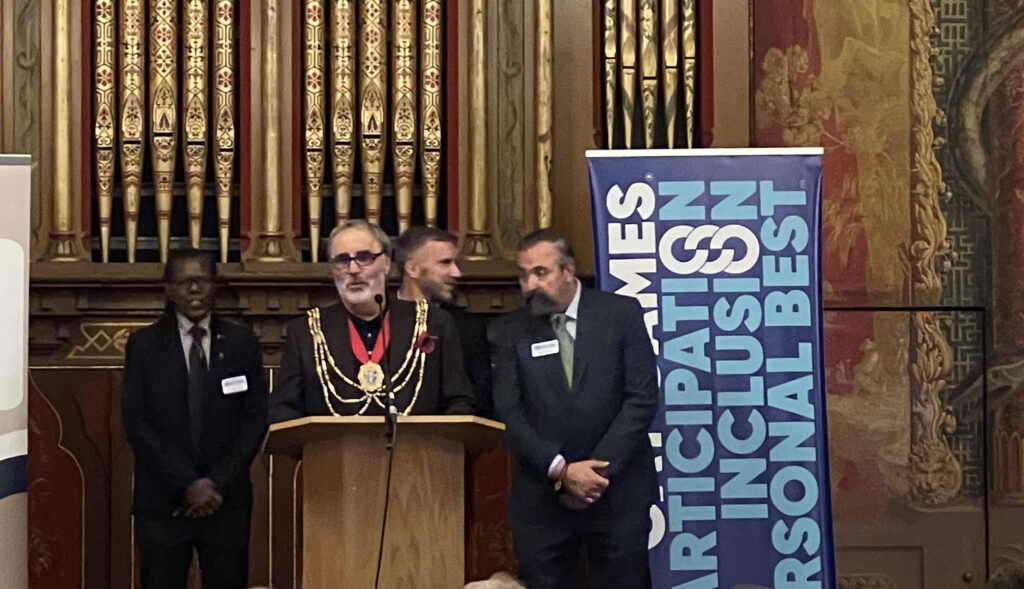 The Mayor of Brighton & Hove Alan Robins (center), FGG Co-President Joanie Evans (far left), FGG Co-President Sean Fitzgerald (right of the mayor), and Site Selection Judge David Killian (Photo Credit: Federation of Gay Games)