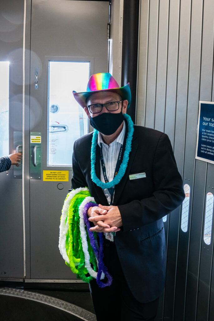 Waiting to hand out leis to passengers arriving on United EQUAL Pride Flight (Photo Credit: United Airlines)