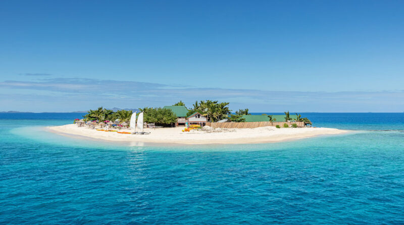 Beautiful small island in the middle of the south pacific ocean with beach huts, lounge chairs, palm trees, surrounded with beautiful clear turquoise water. Islet, Mamanuca Islands, Fiji, Melanesia (Photo Credit: Mlenny/iStock)