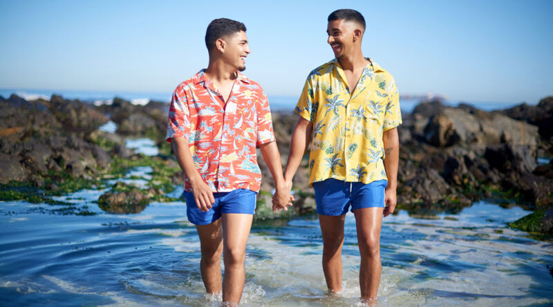 Gay men holding hands and walking on a beach