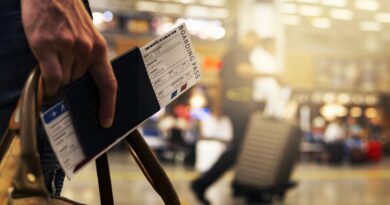 Close photo of man carrying passport and airplane ticket in an airport