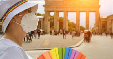 Queer traveler near Brandenburg Gate in Berlin, Germany (Photo Credit: anyaivanova / iStock)