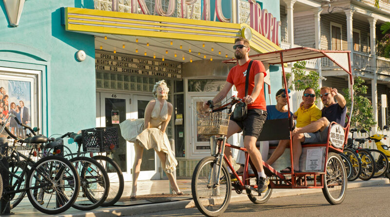 11 Ways to Enjoy the Florida Keys and Key West. In photo: A pedicab provides transportation past the Tropic Cinema Theater featuring a Seward Johnson metallic statue of Marilyn Monroe in a famous pose. (Photo Credit: Mike Freas/Florida Keys News Bureau)