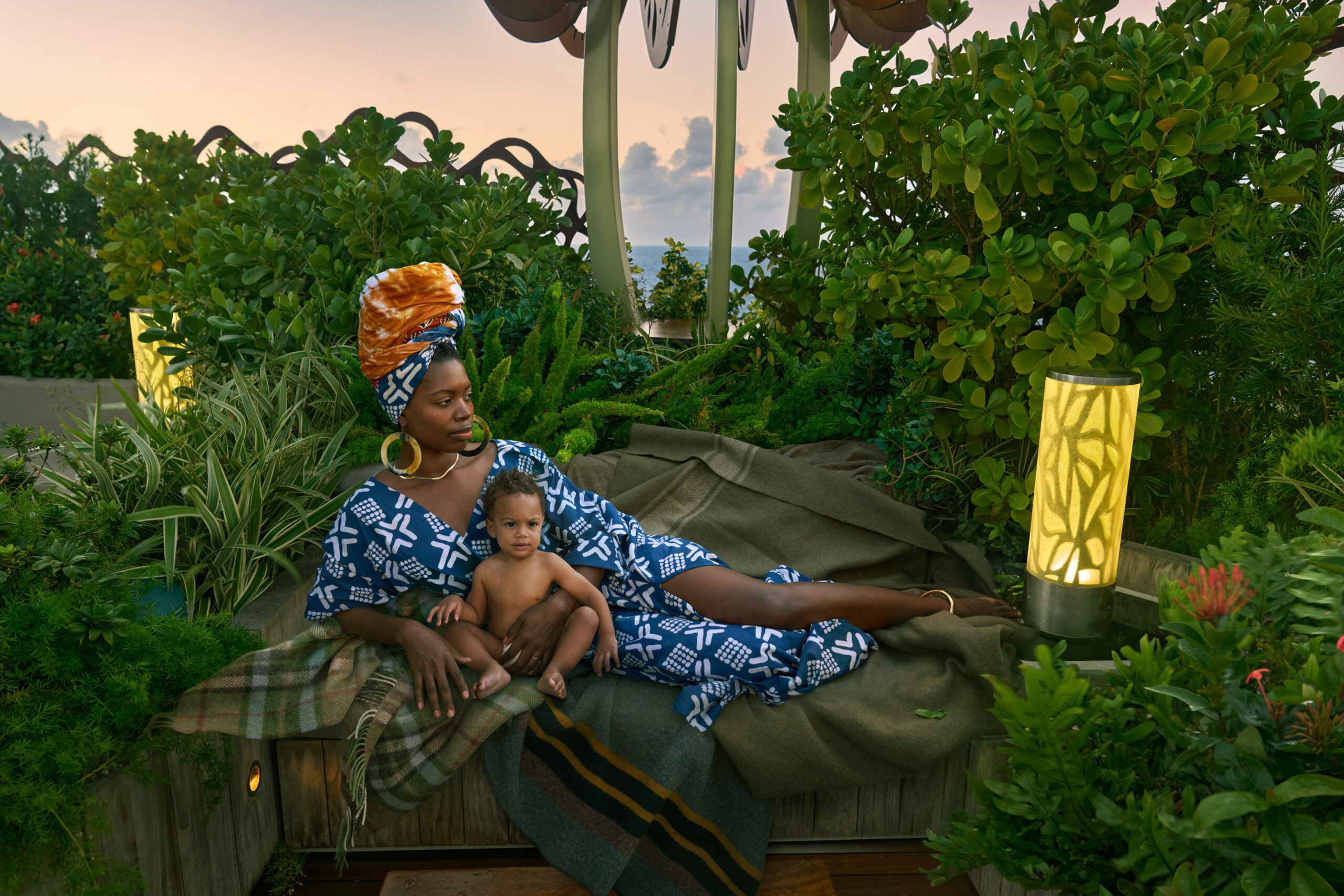 Haitian-born Paola Mathé – entrepreneur, creative director and creator of Fanm Djanm (which means “strong woman” in Haitian Creole) – lounges with her son in the Rooftop Garden onboard Celebrity Apex. (Photo Credit: Annie Leibovitz / Celebrity Cruises / AIPP)