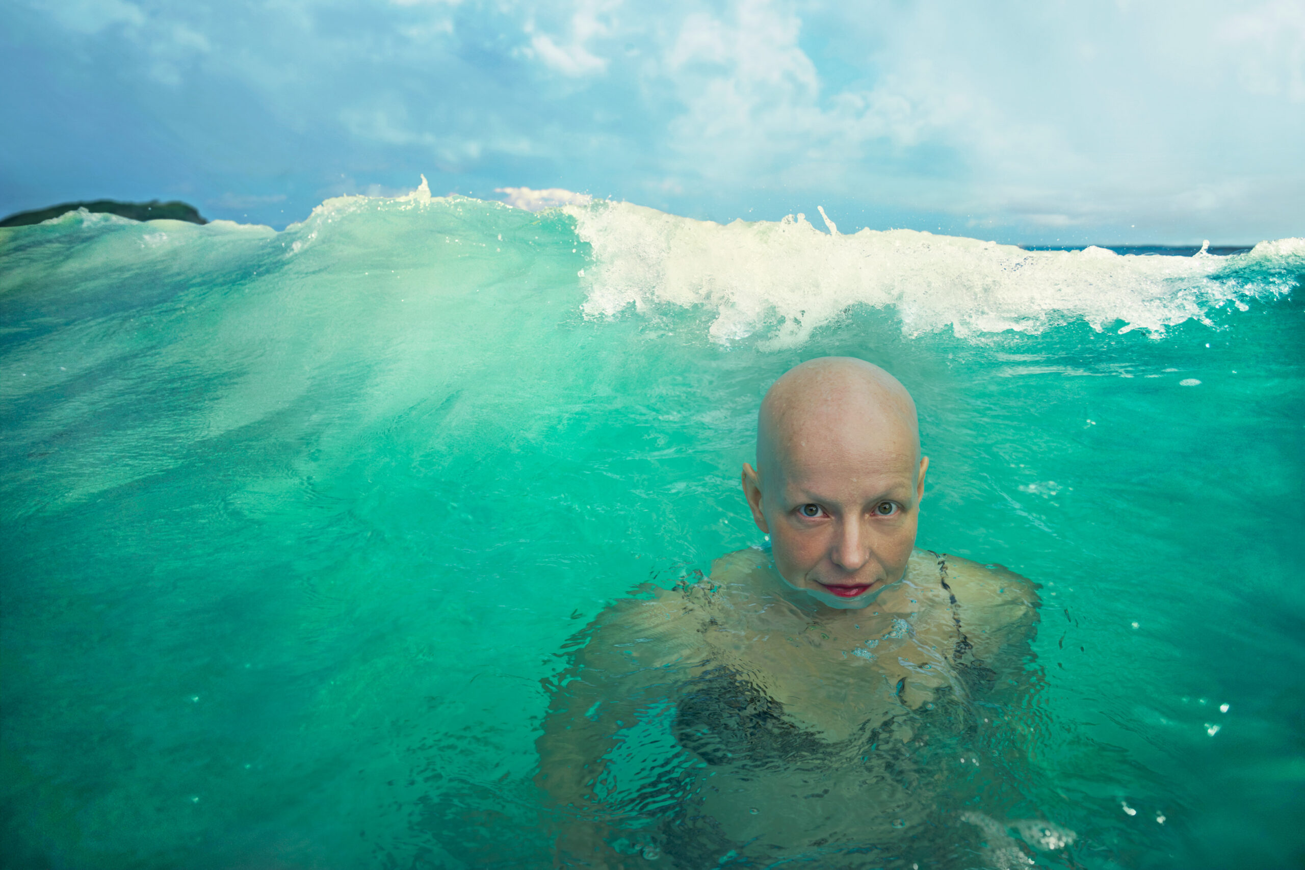Rachel Fleit – a Brooklyn-based writer and creative director of Killer Films Media, and proud advocate for women with Alopecia – takes a dip in the ocean. (Photo Credit: Annie Leibovitz / Celebrity Cruises / AIPP)