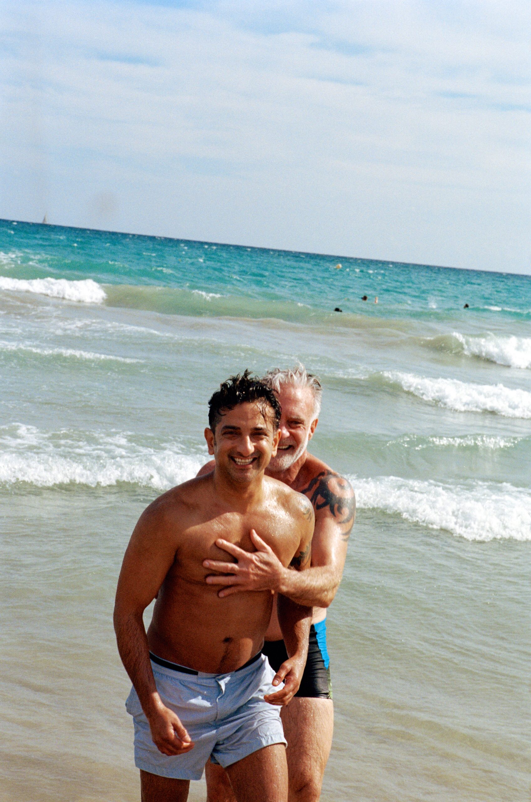 Keen travelers and recently engaged couple, Tim and Shaheen, share a hug in the sea. (Photo Credit: Giles Duley / Celebrity Cruises, AIPP)