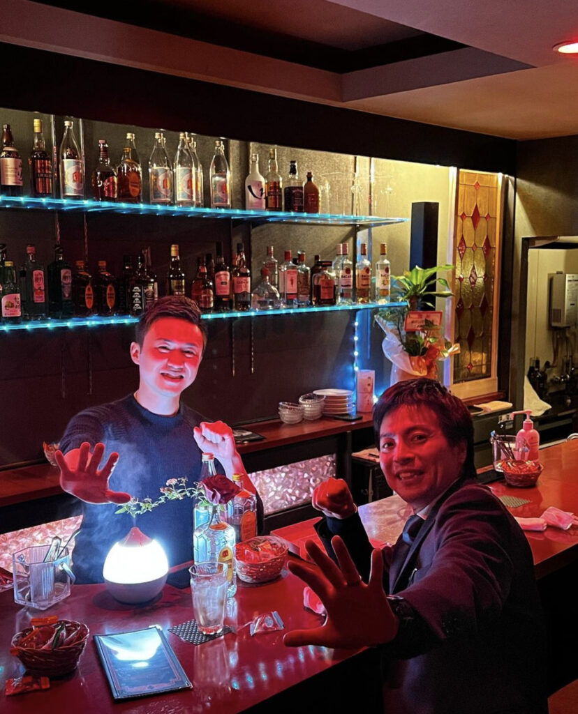 Bar owner Aiki Tanaka with a patron (Photo Credit: @tanakagaykikaku)