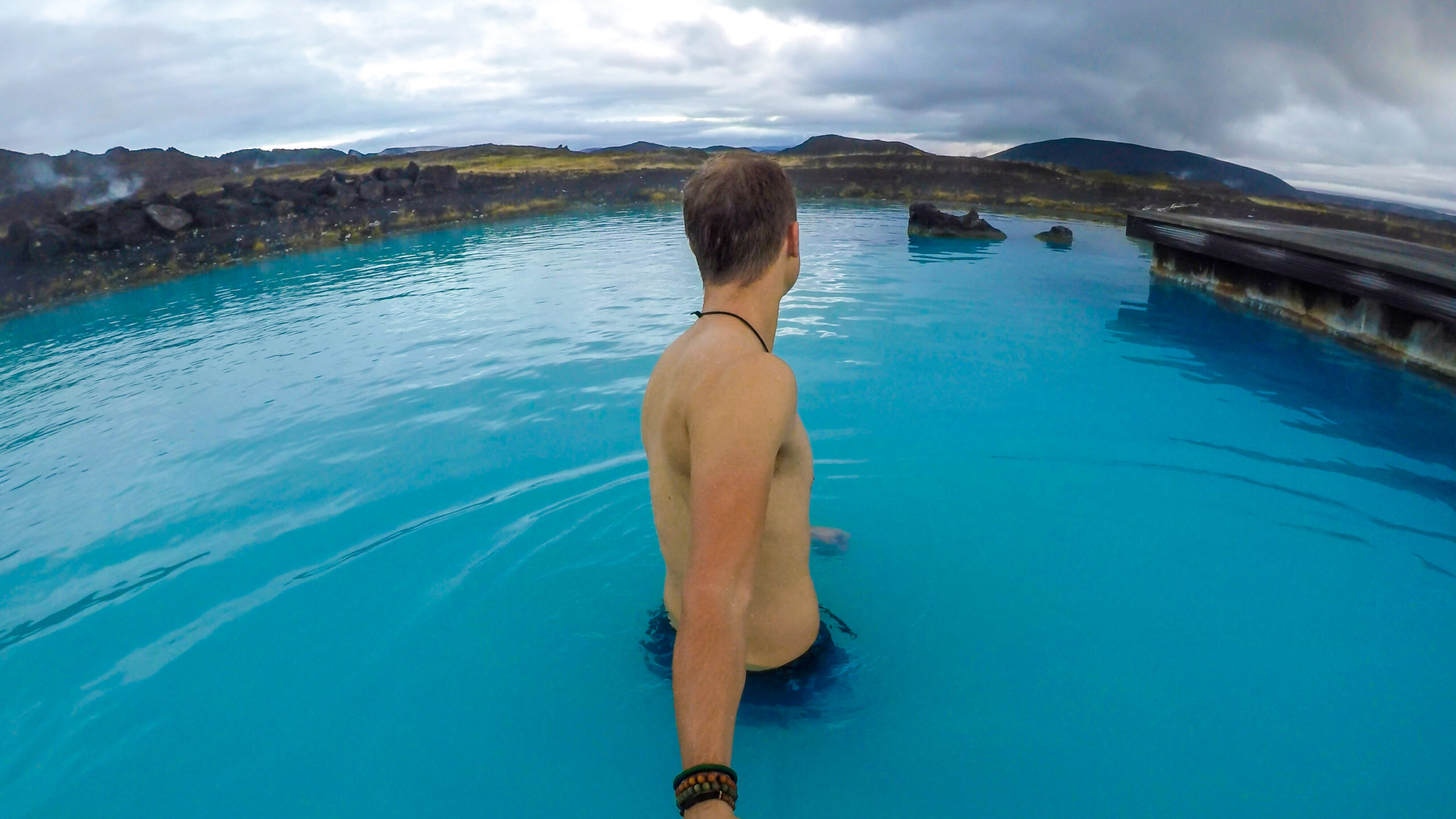 Man holding selfie stick at Myvatn Nature Baths (Photo Credit: Christopher Moswitzer / iStock)