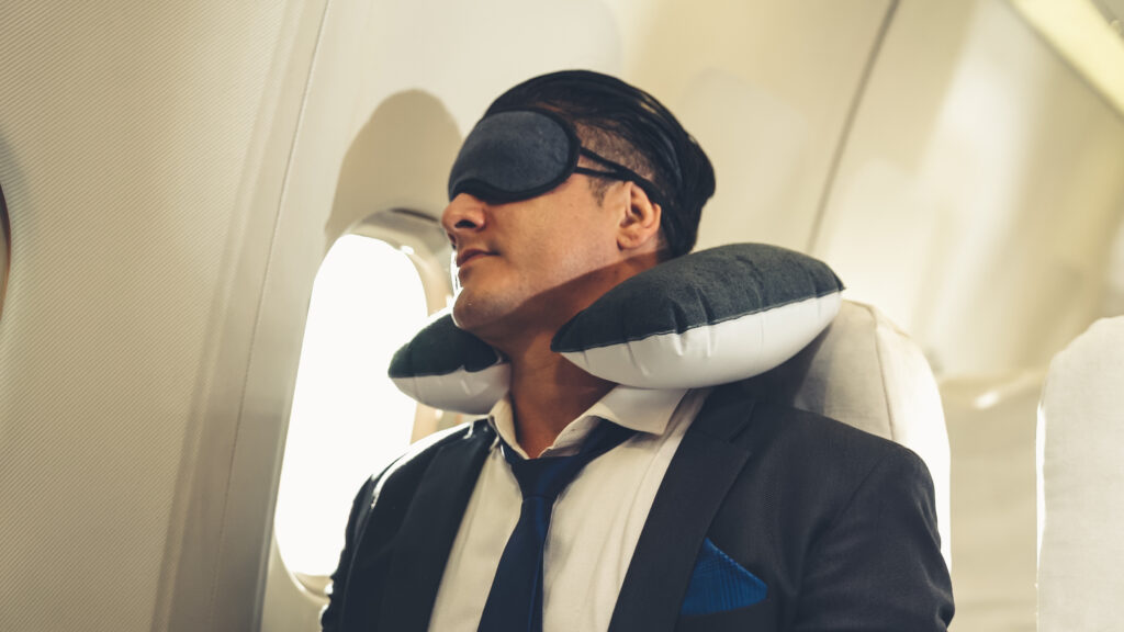 To get some solid sleep on a long-haul flight, you should make sure your neck is supported and wear an eye mask or wrap your head with a pashmina. (Photo Credit: NanoStockk / iStock)