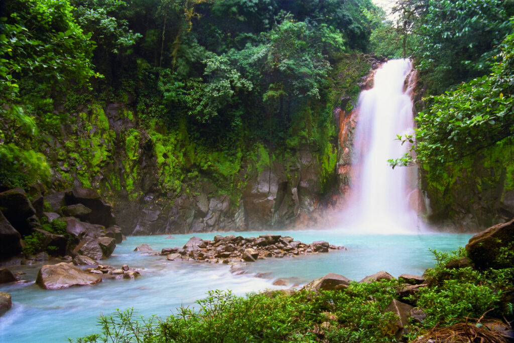 Get a Queer Digital Nomad Visa and you can visit places like Celeste Waterfalls in Costa Rica. (Photo Credit: OGphoto / iStock)