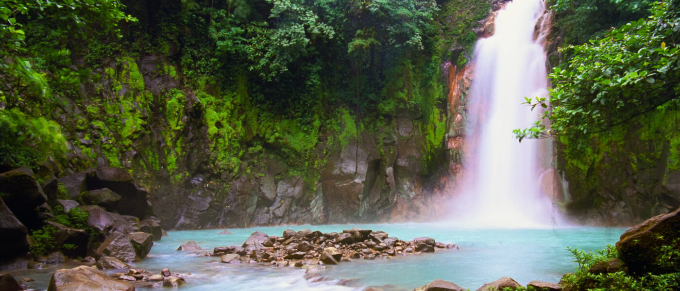 Get a Queer Digital Nomad Visa and you can visit places like Celeste Waterfalls in Costa Rica. (Photo Credit: OGphoto / iStock)
