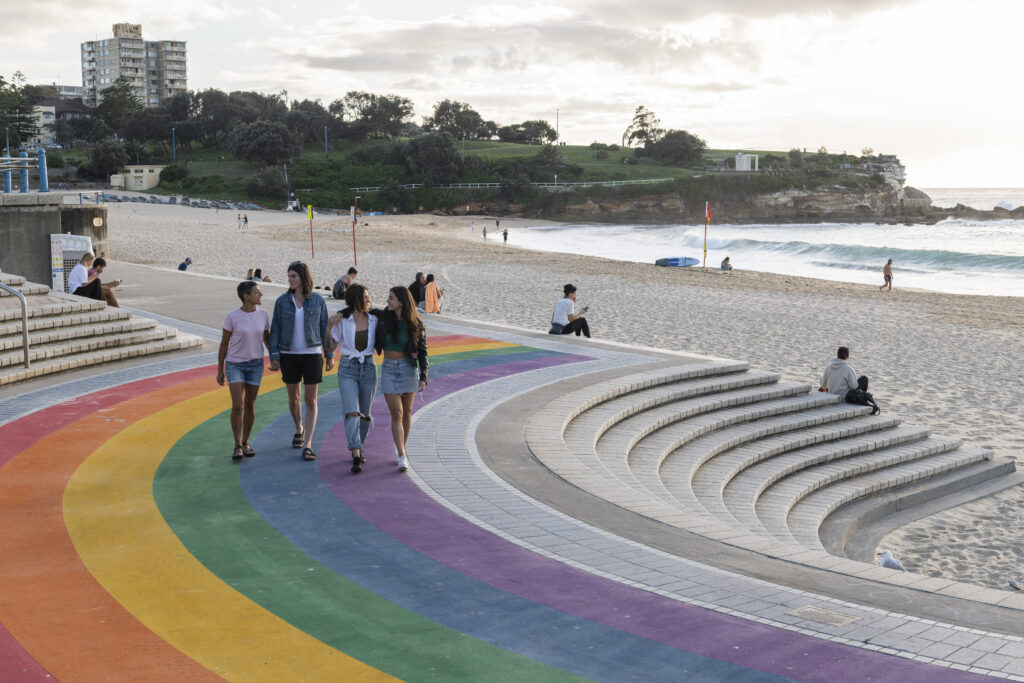 Couples walking along the rainbow path at Coogee Beach. (Photo Credit: Destination NSW)