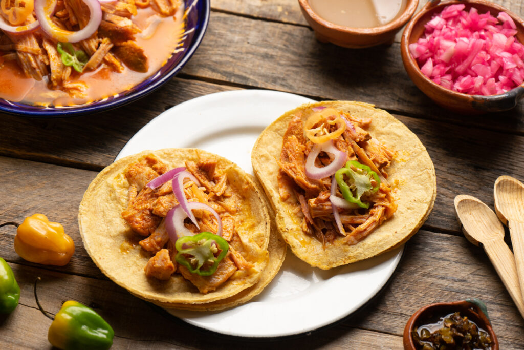 Tacos with conchinita pibil, a traditional Yucatec Mayan slow-roasted pork marinated in  acidic citrus juice. (Photo Credit: carlosrojas20 / iStock)