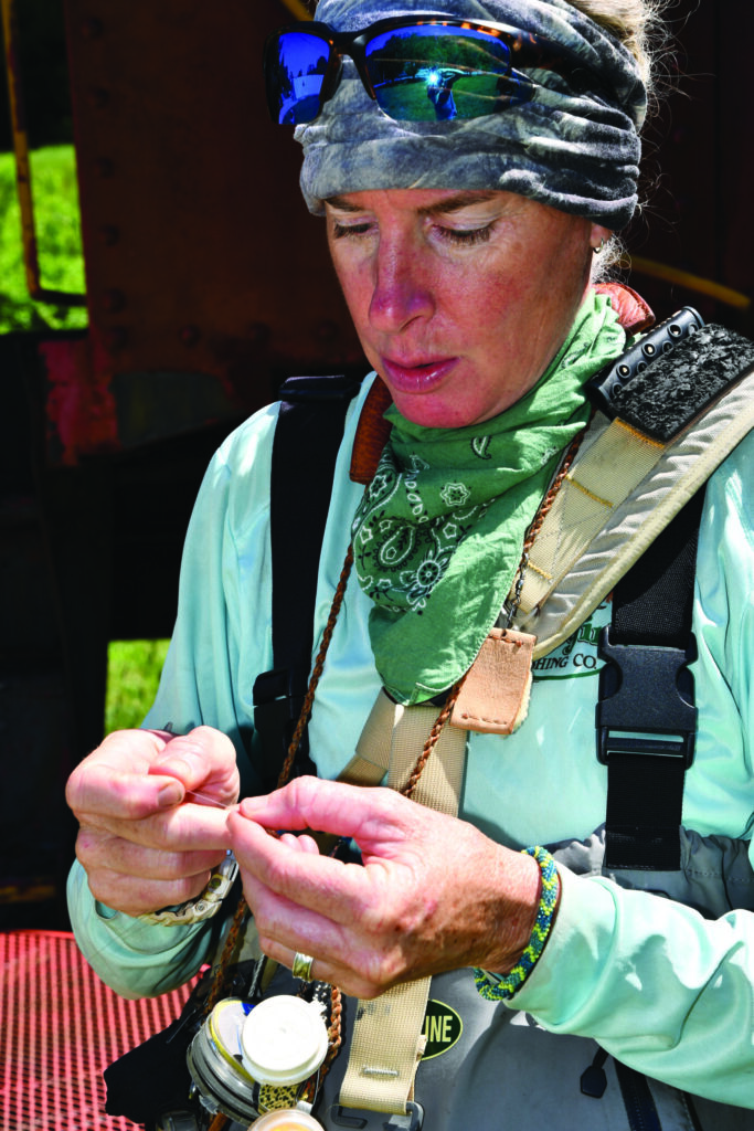 Kelly McCoy baits a hook (Photo courtesy of RiverGirl Fishing Company)