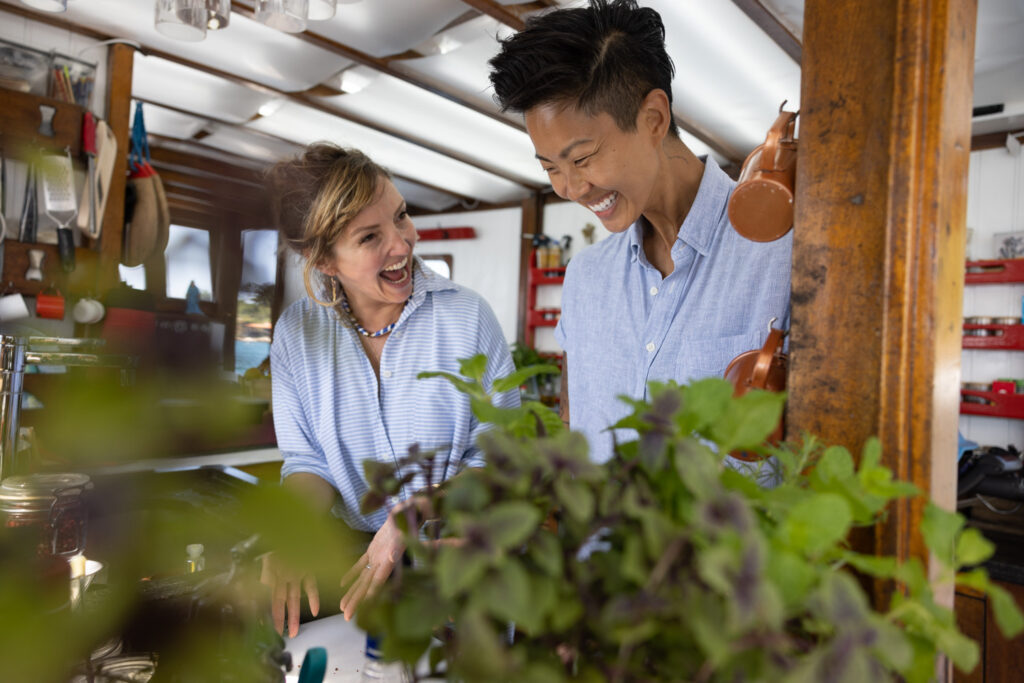 Chef Kristen Kish and Gisela Schmitt, co-owner and chef of Sem Pressa, smile while working on their culinary creation in Paraty, Brazil. (Photo Credit: National Geographic for Disney/Autumn Sonnichsen)