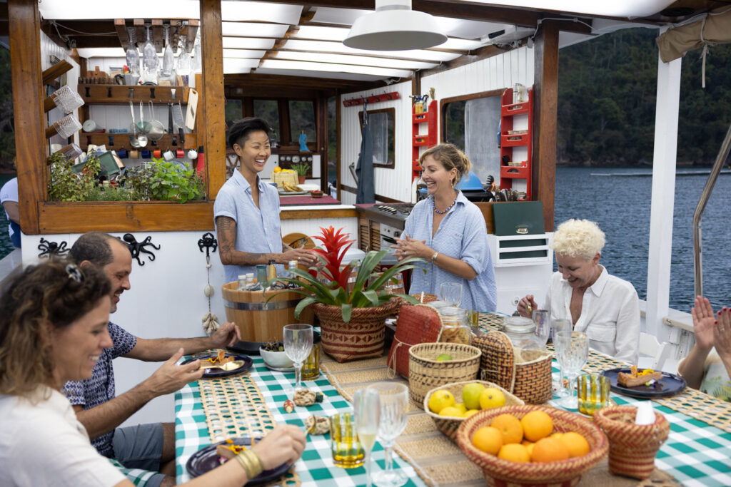 Chef Kristen Kish and Gisela Schmitt, co-owner and chef of Sem Pressa, talk about the meal they served to their guests in Paraty, Brazil. (Photo Credit: National Geographic for Disney/Autumn Sonnichsen)