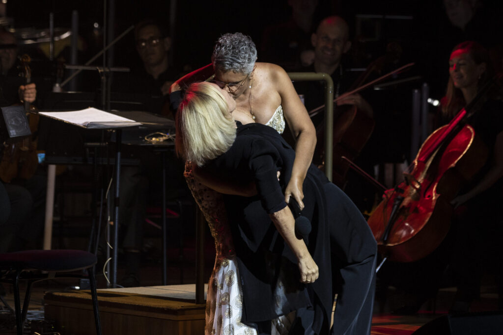 Deborah Cheetham Fraillon kisses her wife Nicolette Fraillon on stage at the Sydney Opera House (Photo Credit: Joseph Mayers)