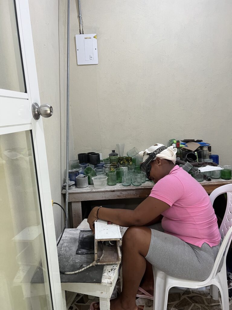 Green Apple employee buffing a glass cup. (Photo Credit: Blue Apple Beach)