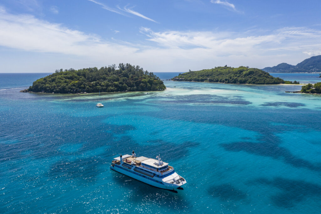 Aerial of M/Y Pegasos cruise ship in clear turquoise waters in St. Anne Marine National Park (Photo Credit: Variety Cruises)