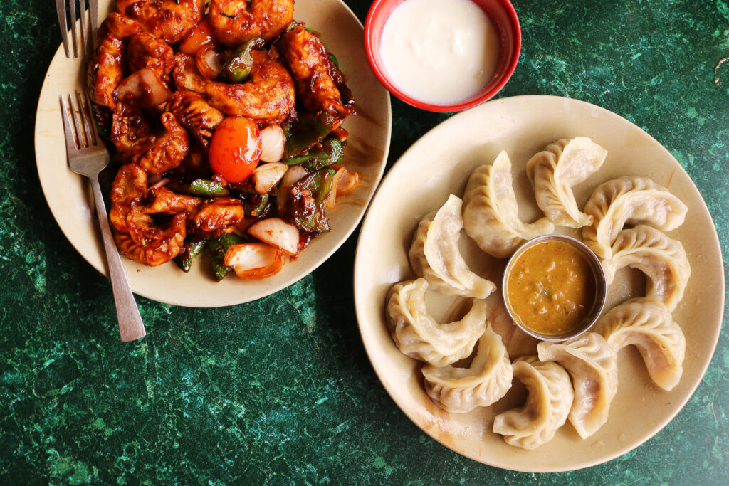 Nepali popular snack - Steamed momo and spicies fried momo served with chutney and curd (Photo Credit: Kondoruk / Shutterstock)