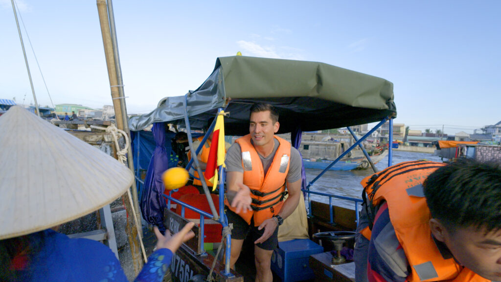 In Vietnam, Ian and Joe make their way along the Mekong Delta to deliver tangerines, dragonfruit, and lemons to floating markets. (Photo Credit: CBS)