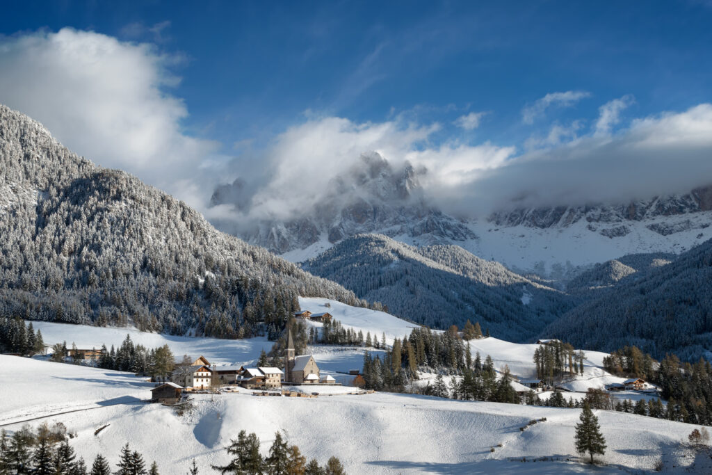 The small village of St. Magdalena is covered with a layer of fresh snow with the Dolomites mountain peaks in the background. (Photo Credit: Envato Elements)